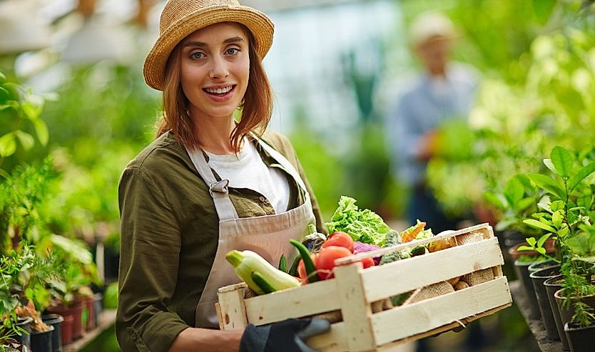 young girl - farmer holds basket with vegetables